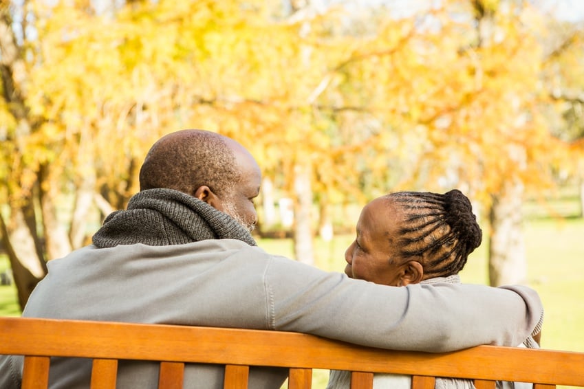 Happy senior couple discussing together on a bench