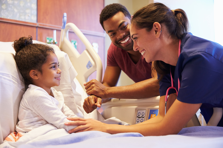 Pediatric Nurse Visiting Father And Child In Hospital Bed
