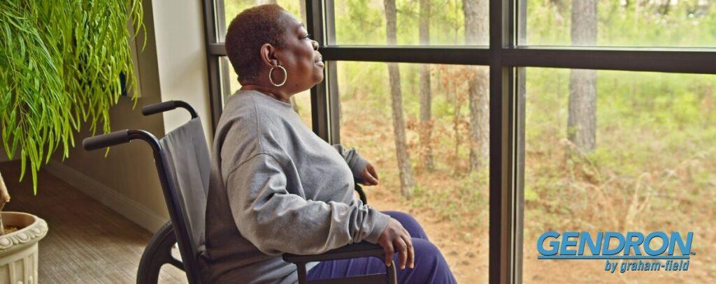 Woman in wheelchair looking out the window